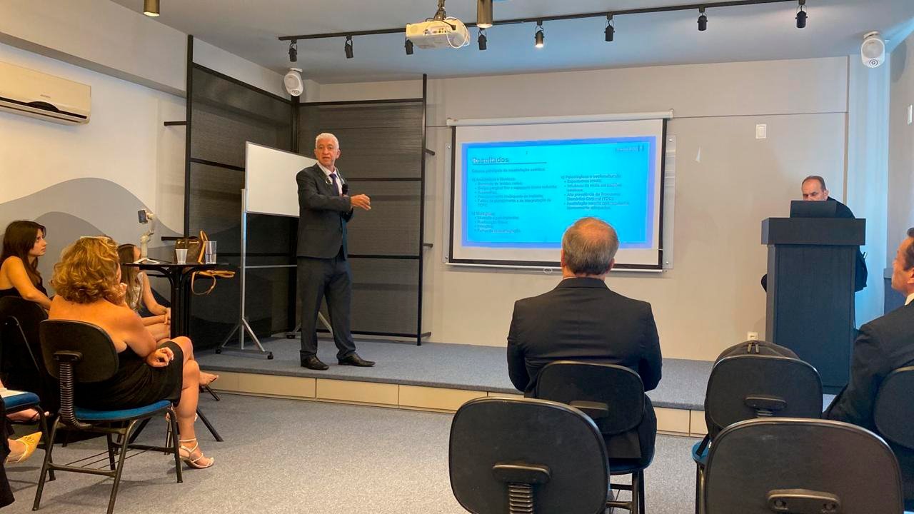 Dr. André Lima apresentando trabalho em evento acadêmico de cirurgia bucomaxilofacial diante de plateia